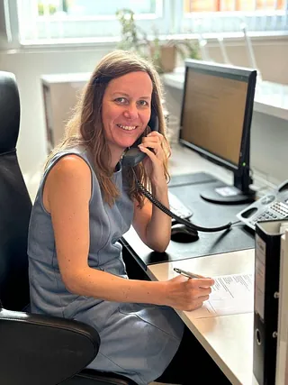 Evelyne Eßl sitzend mit Telefon in der Hand